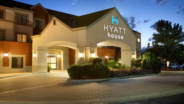 A Hyatt House hotel with a prominent entrance, landscaped garden, and a clear sky. - HYATT house Denver Tech Center (Greenwood Village)