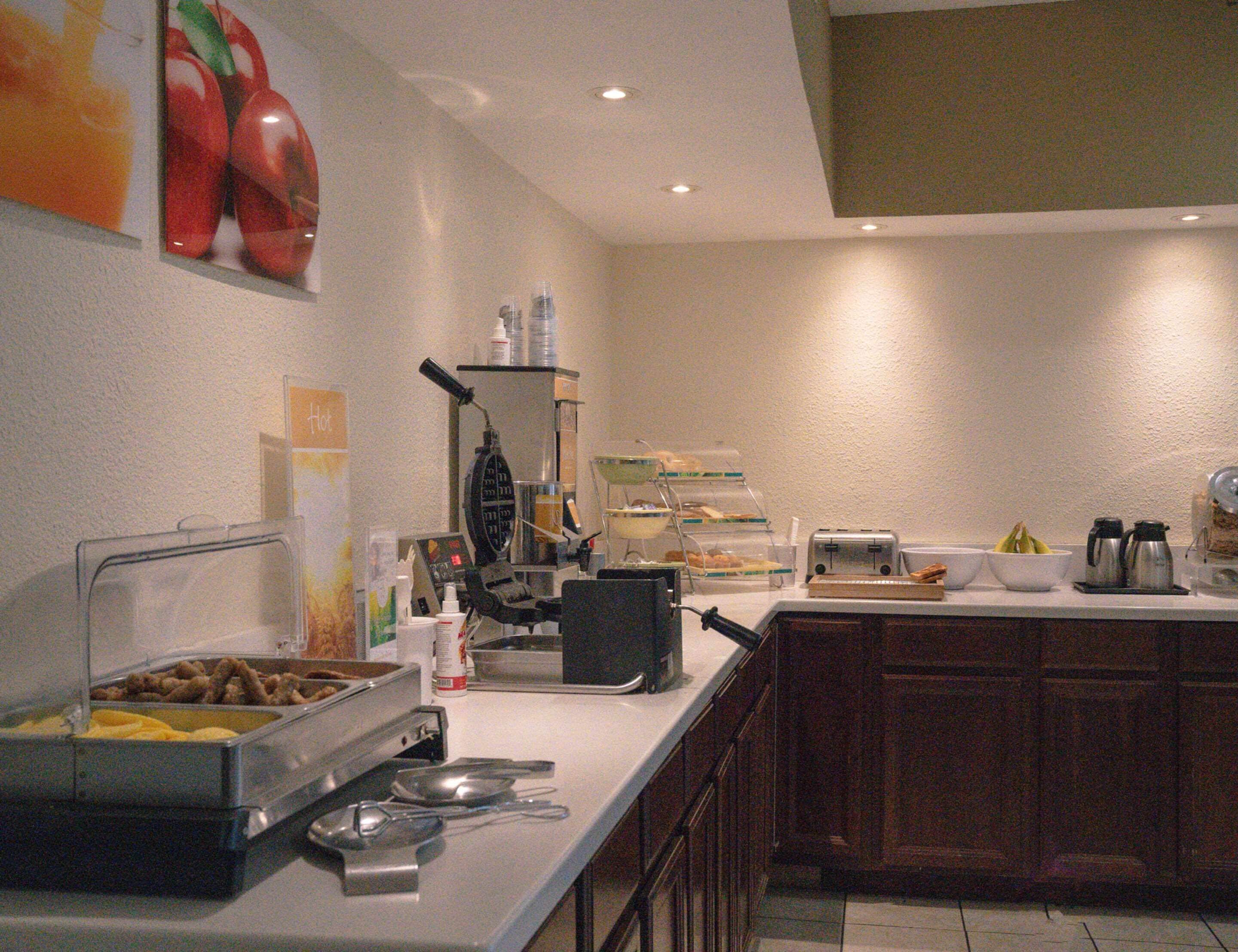 A buffet area with various food items, a coffee machine, and a toaster.