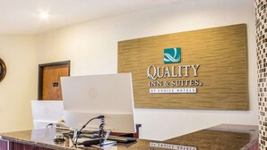 A hotel reception desk with a sign reading "Quality Inn & Suites by Choice Hotels" and a computer on the desk. - Quality Inn & Suites Yuma (Yuma)