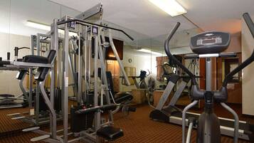 A gym with various exercise equipment including a treadmill, elliptical, and weight machines.