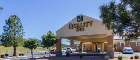 A Quality Inn with a clear entrance, parking lot, and a few cars parked in front.