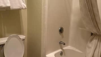Un baño con inodoro, bañera y cortina de ducha.