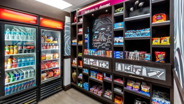 A vending machine area with snacks, drinks, and a 'Welcome to Denver' sign. - Hampton Inn Denver-International Airport (Denver)