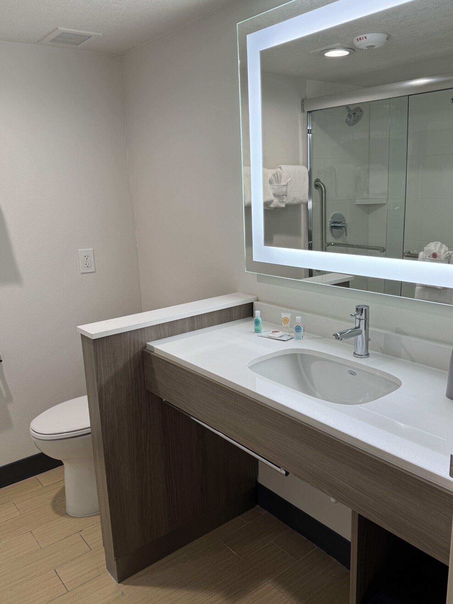 Un baño moderno con un lavabo blanco, un espejo y un inodoro.