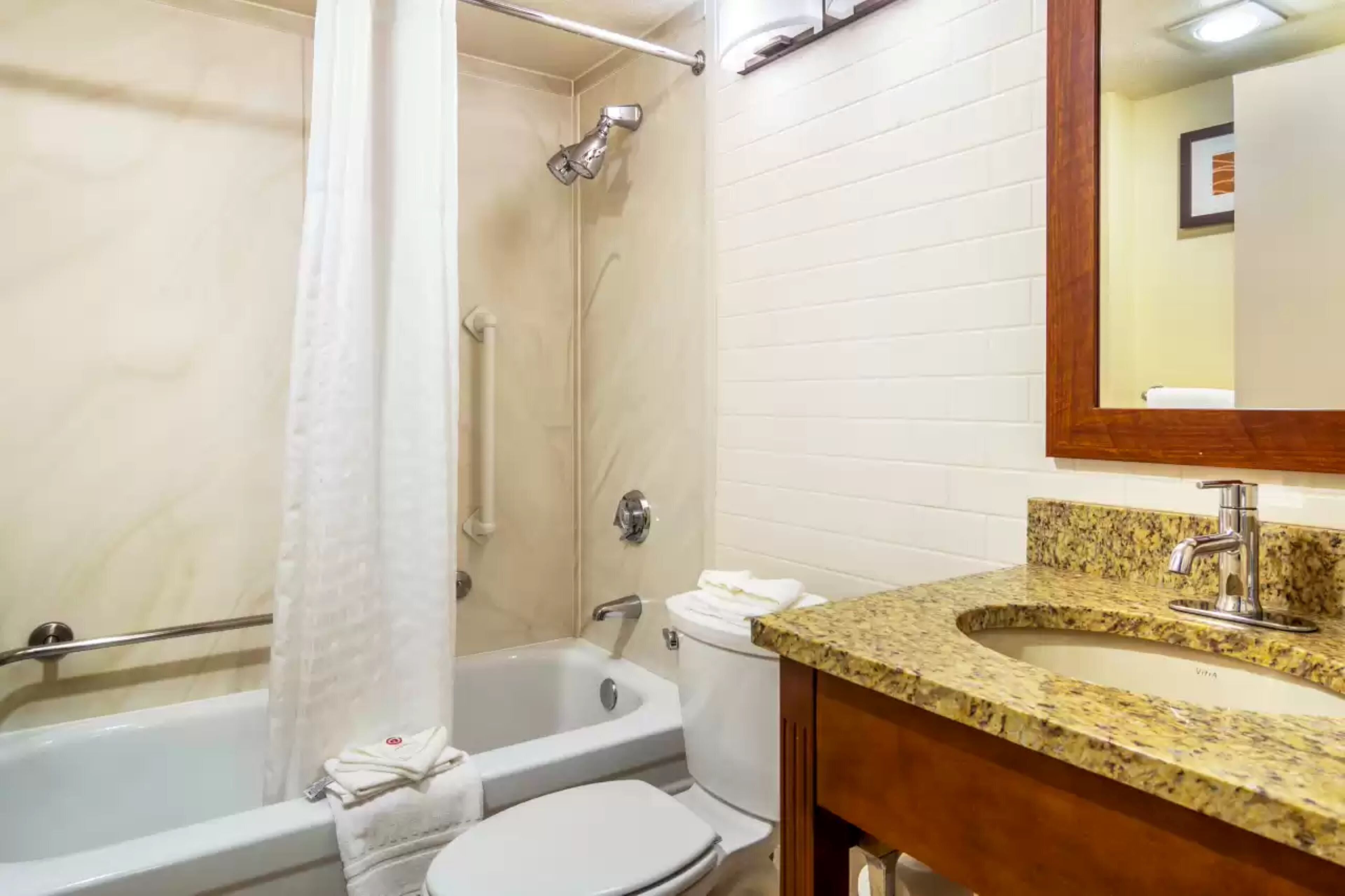 Un baño con bañera, inodoro y lavamanos.