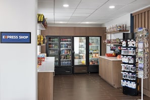 A retail space with a sign reading "EXPRESS SHOP," shelves stocked with snacks and beverages, and a display of various items. - Holiday Inn Express Denver Central North by IHG (Denver)