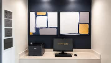 A hotel reception desk with a computer, printer, and a sign indicating it is a smoke-free building.