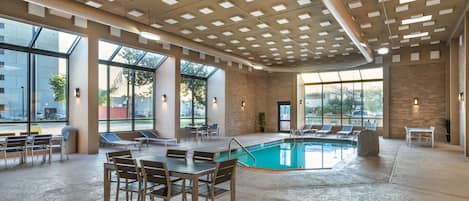 Una piscina techada, sillones reclinables de piscina