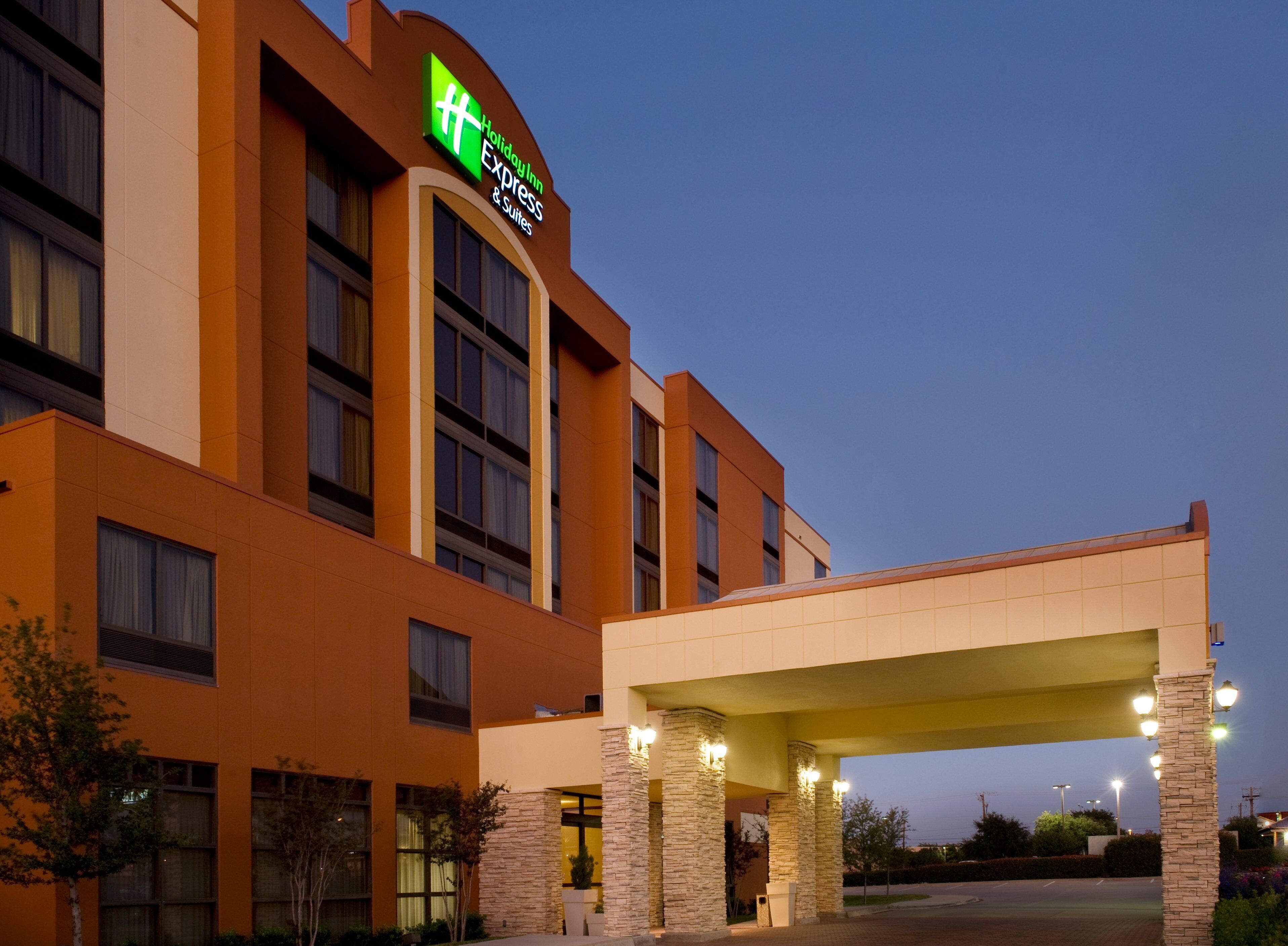A Holiday Inn Express building with a prominent sign, a covered entrance, and stone pillars.