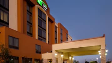 A Holiday Inn Express building with a prominent sign, a covered entrance, and stone pillars.