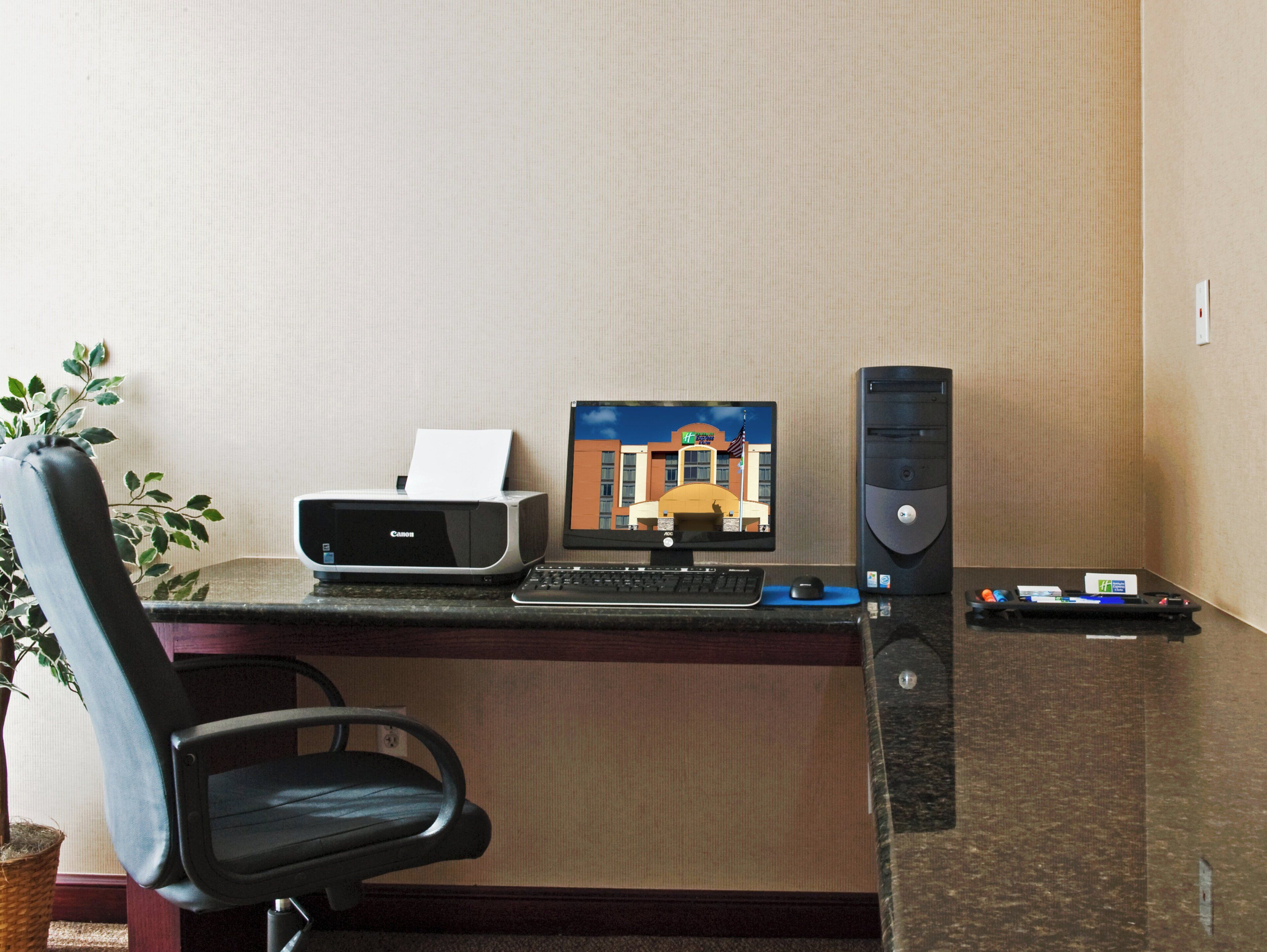 Un bureau d’hôtel équipé d’une imprimante, d’un écran d’ordinateur et d’un clavier.