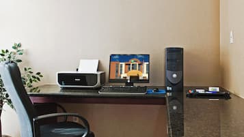 Un bureau d’hôtel équipé d’une imprimante, d’un écran d’ordinateur et d’un clavier.