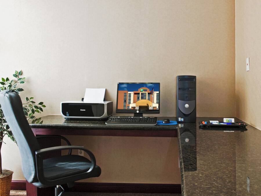 Un bureau d’hôtel équipé d’une imprimante, d’un écran d’ordinateur et d’un clavier.