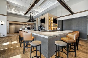 A modern bar area with a central island, bar stools, and a kitchen counter with appliances. - Hyatt Place San Antonio-Northwest/Medical Center (San Antonio)