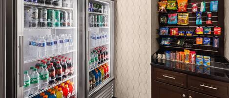 A vending machine stocked with snacks and beverages, and two refrigerated display cases with various drinks.