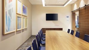 A conference room with a long table, blue chairs, a flat-screen TV, and framed artwork on the wall. - Holiday Inn Express - Layton by IHG (Layton)