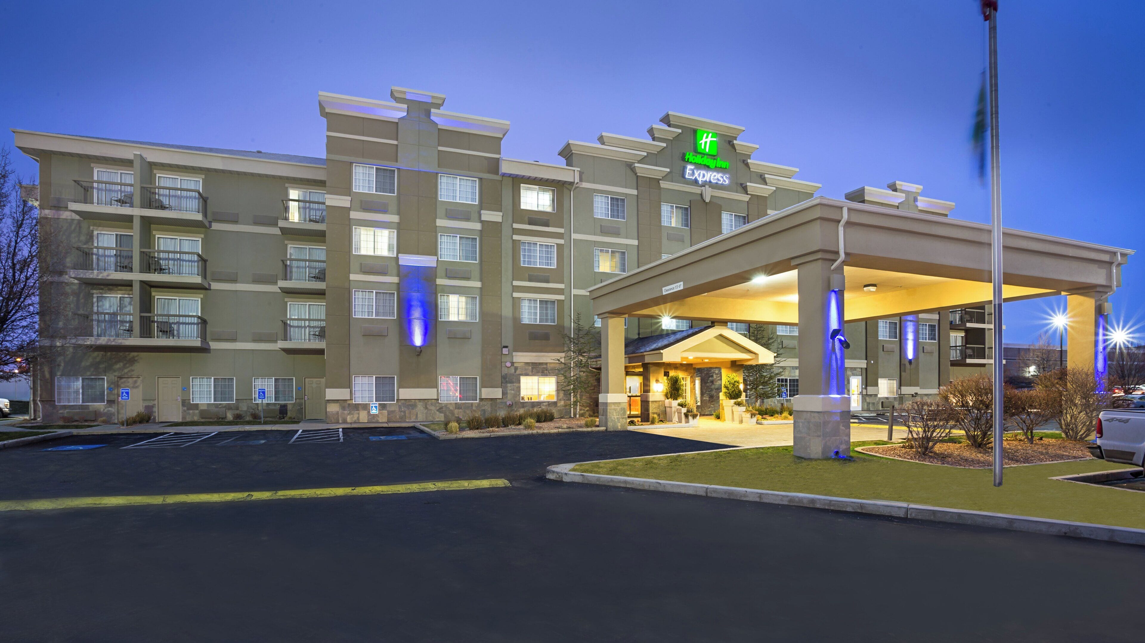 A multi-story hotel with a covered entrance and a parking lot.