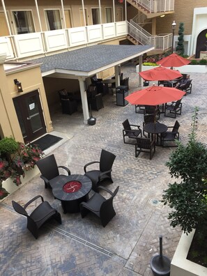 An outdoor patio area with round tables and chairs, red umbrellas, and a covered seating area. - Best Western Atlanta Downtown (Atlanta)