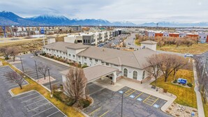 A multi-story building with a parking lot in front. - Best Western Timpanogos Inn (Lehi)