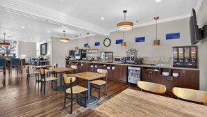 A modern restaurant with wooden flooring, multiple seating areas, and a kitchen counter. - Best Western Timpanogos Inn (Lehi)