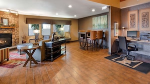 A spacious living area with a fireplace, a dining table, and a bar area.