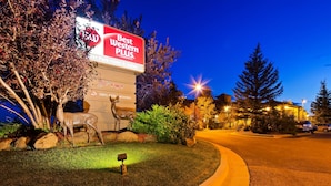 A hotel sign with a deer sculpture and a mailbox.