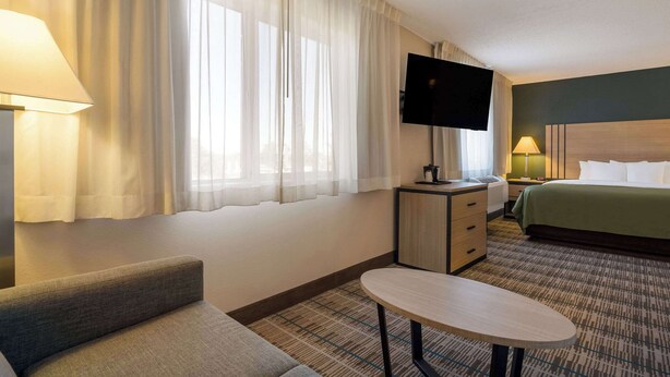 Una habitación de hotel con cama, televisión, escritorio, silla y mesa.