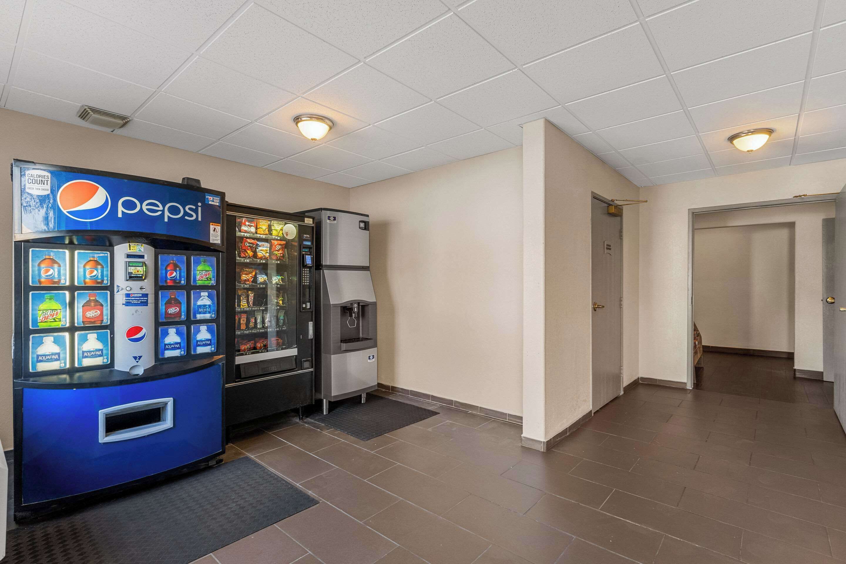Een schone, goed verlichte gang met een Pepsi-automaat en een gekoelde vitrine.