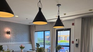 A modern dining area with a marble table, black chairs, and pendant lighting. - Hampton Inn Conyers (Conyers)