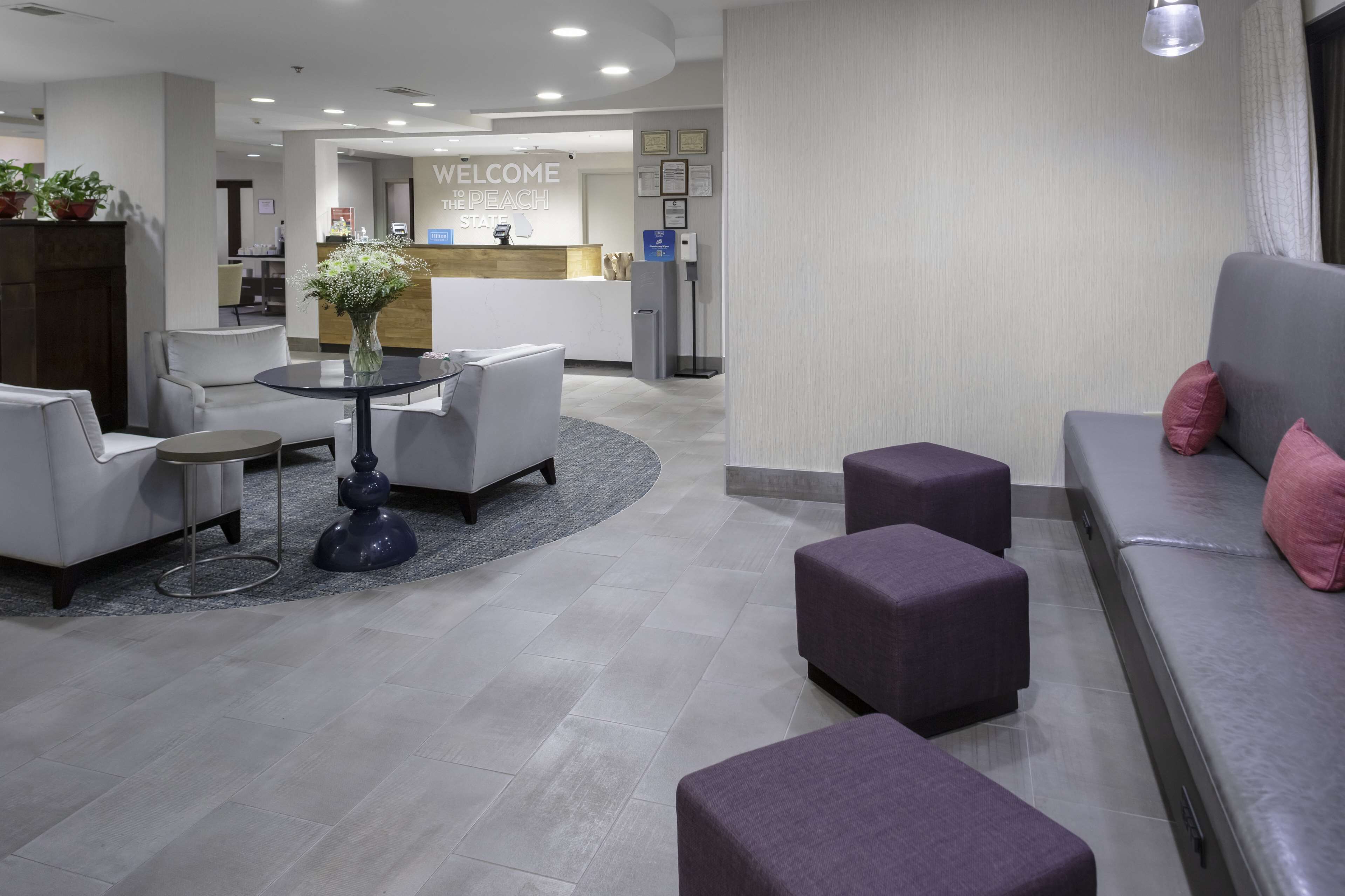 Un moderno vestíbulo de hotel con mostrador de recepción, zona de estar y recepción.