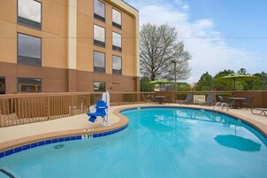 Una piscina al aire libre, sillones reclinables de piscina