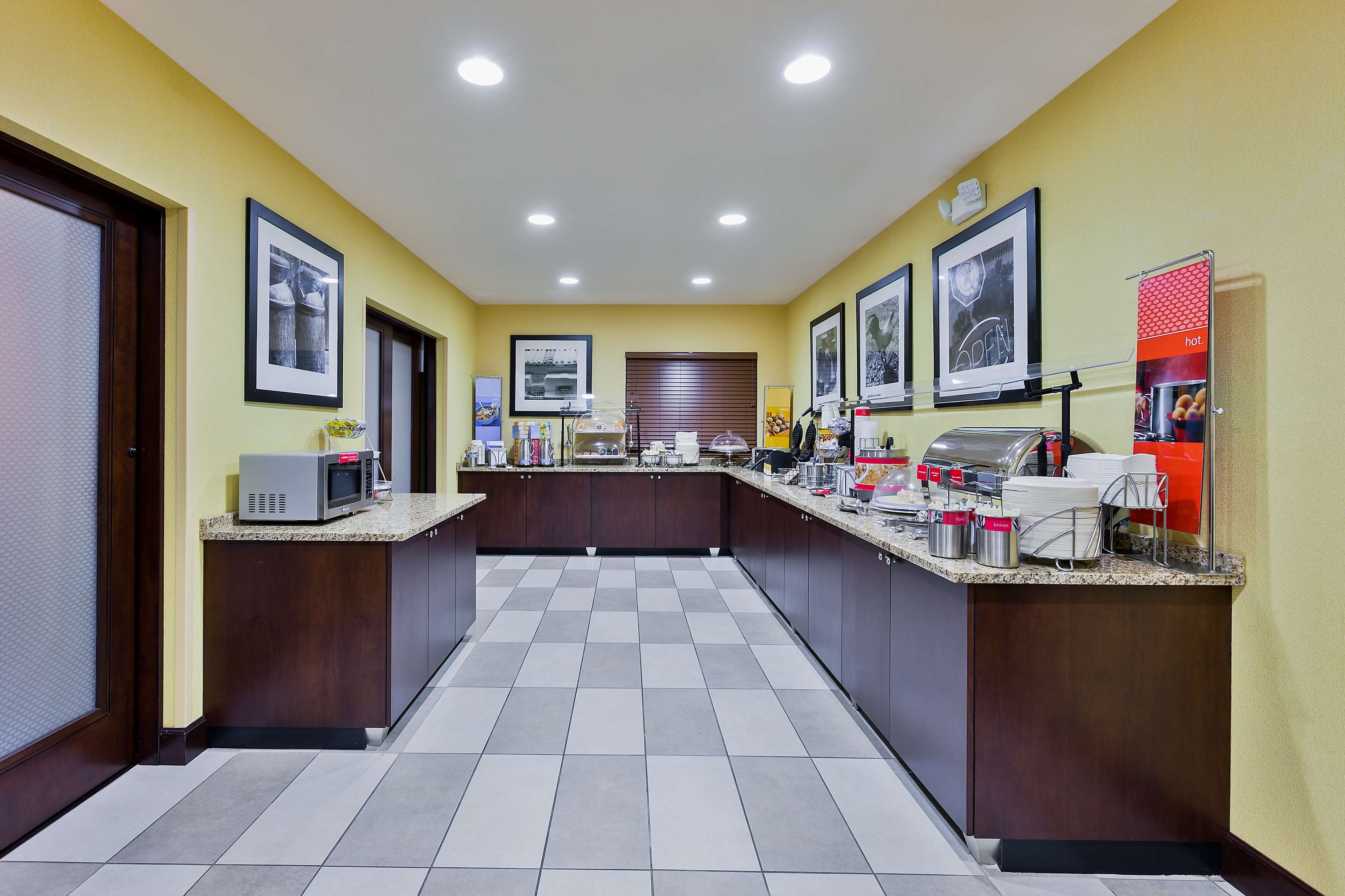 A modern kitchen with a central island, equipped with a microwave, coffee machine, and various appliances.