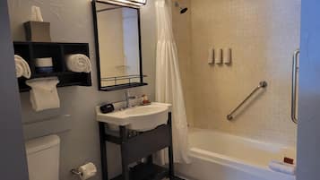 Un baño con ducha, inodoro, lavabo y espejo.