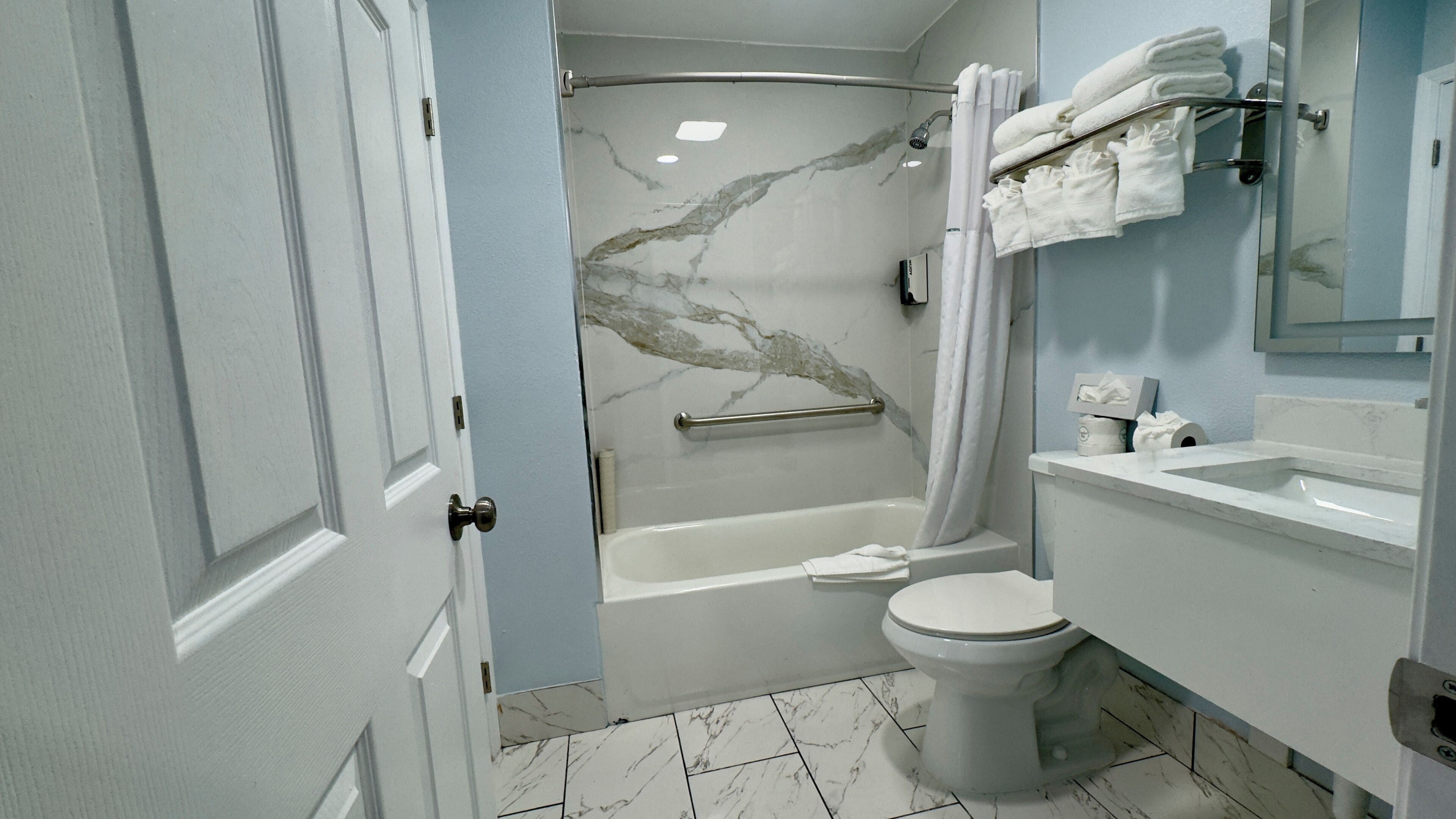A bathroom with a bathtub, toilet, and a shower with a glass door.