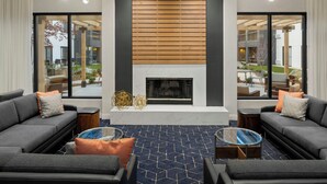 Un salon moderne avec une cheminée, deux canapés et une table basse.
