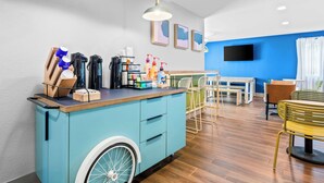 A modern kitchen with a blue island, wooden cabinets, and a wheelchair-accessible design.