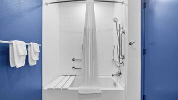 A modern bathroom with a bathtub, shower, and towel rack.