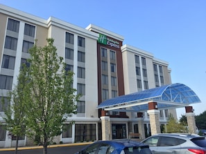 Un hôtel Holiday Inn Express au design moderne, doté d’un grand auvent d’entrée en verre et de plusieurs étages dont l’architecture est harmonieuse.