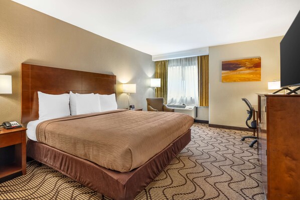 A hotel room with a large bed, a desk, a chair, and a television. - Best Western John Muir Inn (Martinez)