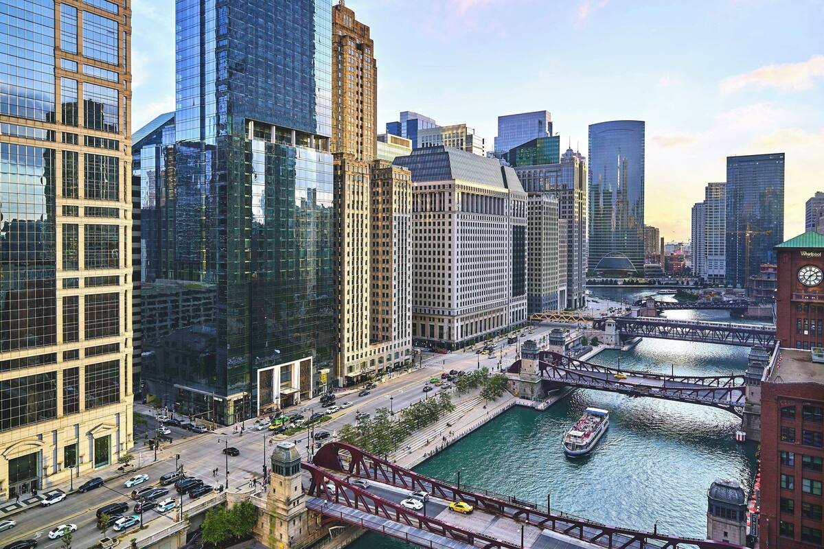 Une vue urbaine avec des immeubles modernes de grande hauteur, une rivière et un pont.