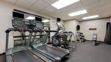 A gym with treadmills, an elliptical, and a weight bench.