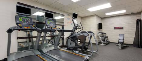 A gym with treadmills, an elliptical, and a weight bench.