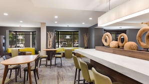 A modern restaurant with a bar area, seating arrangements, and large windows providing views. - Sonesta Select Tempe Downtown (Tempe)