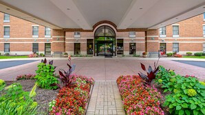 A building entrance with a brick facade, large windows, and a central archway. - Comfort Inn Indianapolis North - Carmel (Indianapolis)
