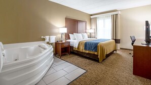 A hotel room with a large bed, a separate bathroom with a bathtub, a desk, and a television. - Comfort Inn Indianapolis North - Carmel (Indianapolis)