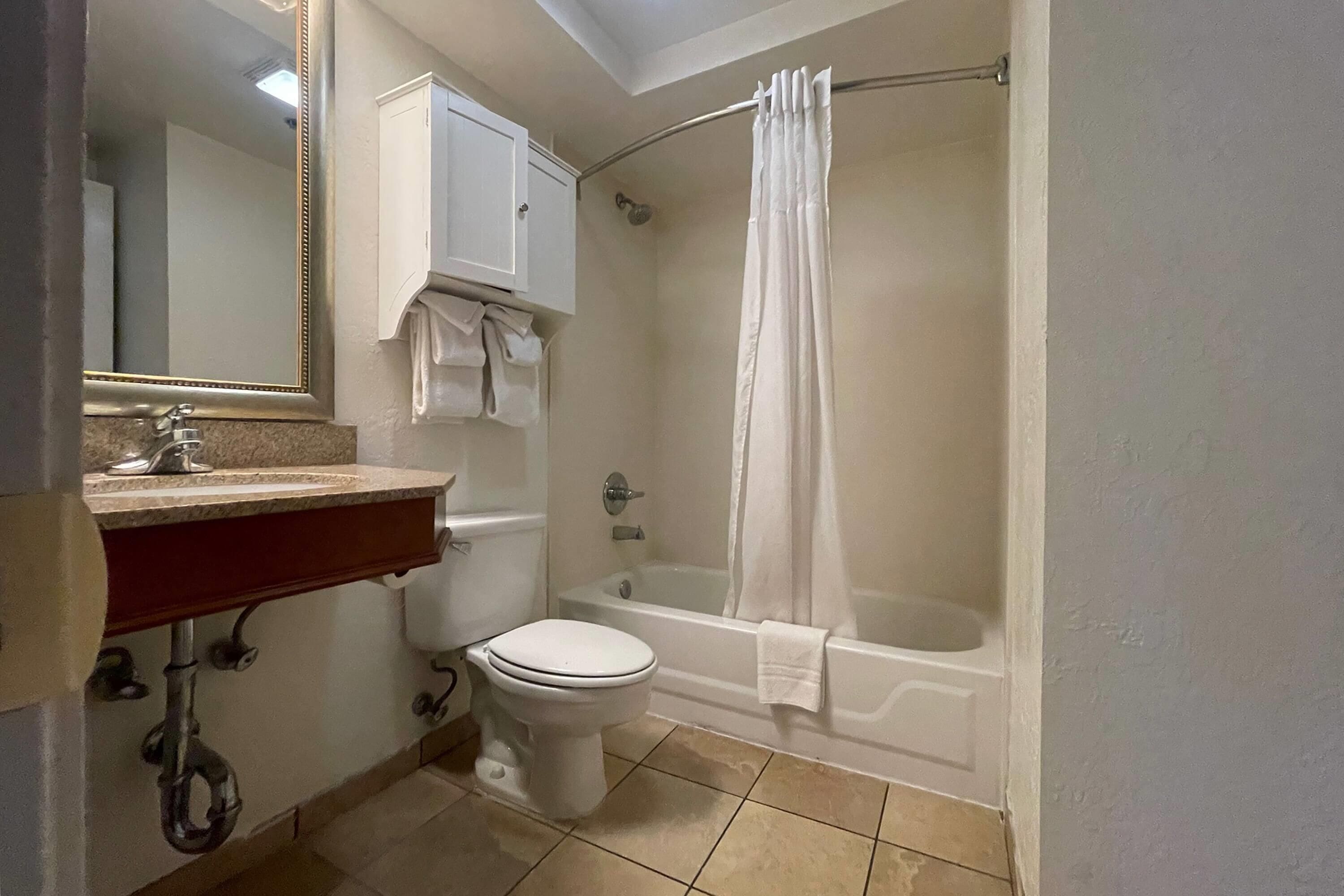 A bathroom with a toilet, sink, and bathtub.