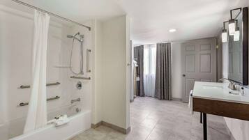A modern bathroom with a bathtub, shower, and vanity.