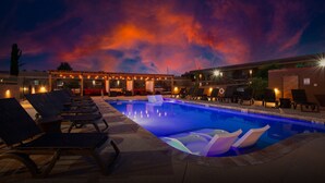 A pool area with lounge chairs and a covered seating area under a sunset sky. - GreenTree Inn Sedona (Sedona)