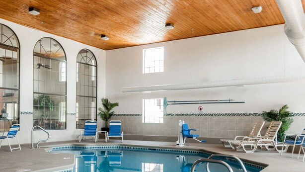 An indoor swimming pool with clear water, surrounded by lounge chairs and a wooden ceiling. - Quality Inn & Suites Albuquerque West (Albuquerque)