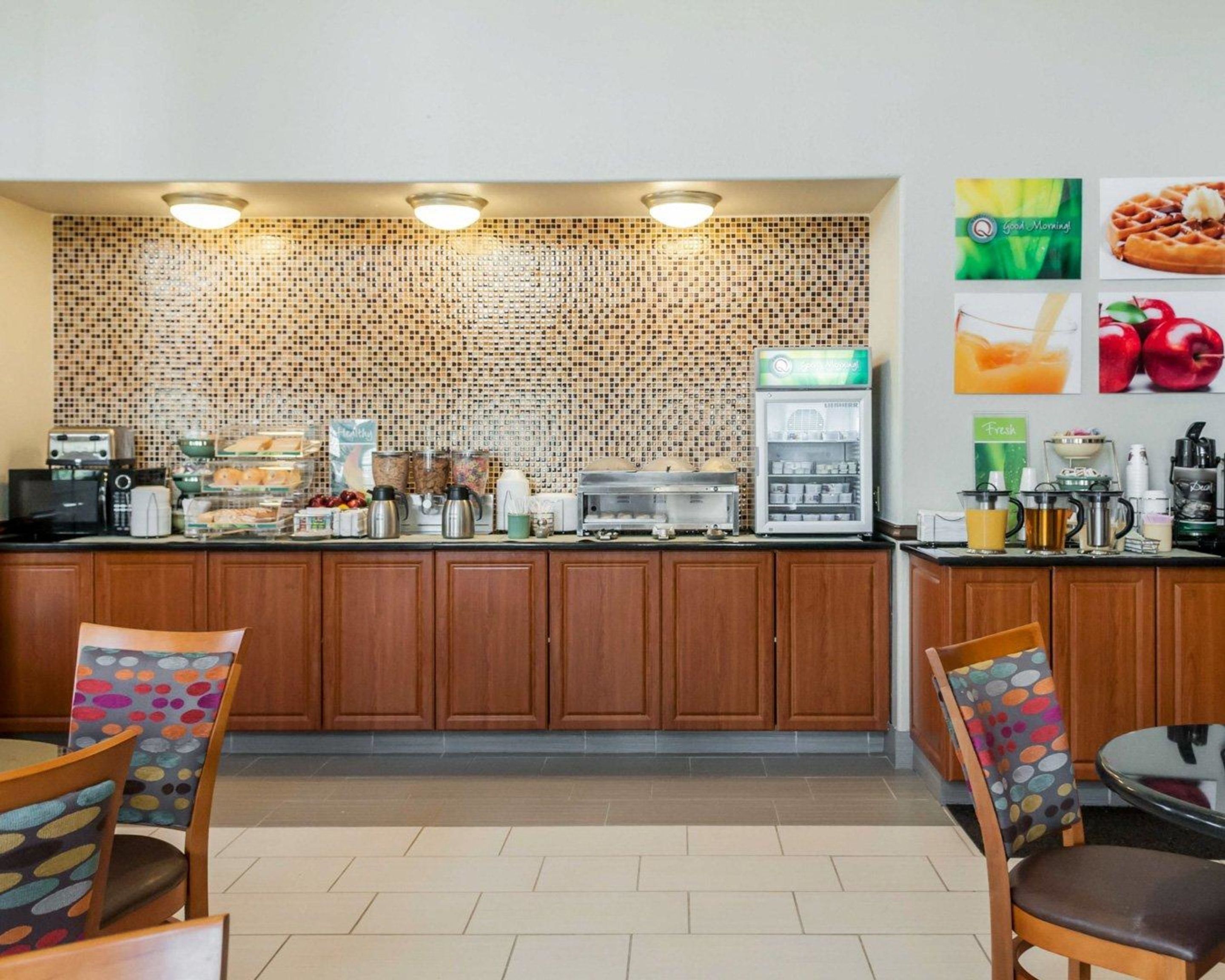 A breakfast bar with a mosaic wall, a coffee machine, and a refrigerator.